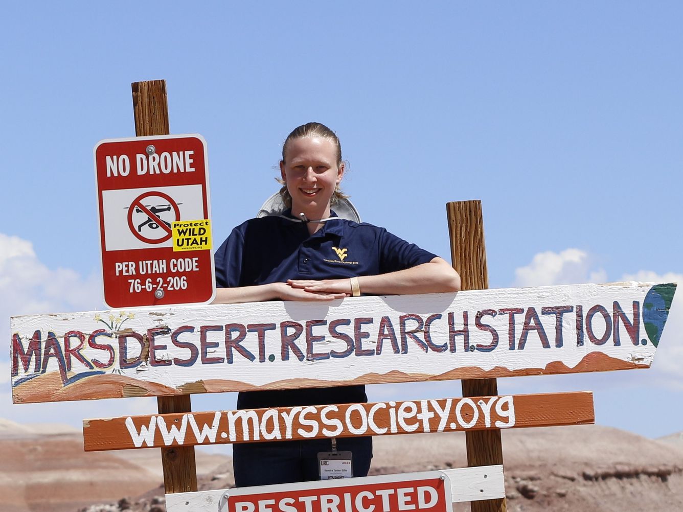 Person standing behind Mars Desert Research Station sign